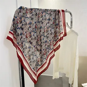 Detail view of 90cm cotton linen square scarf with floral print and red border