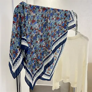 Detail view of blue floral cotton linen square scarf with geometric border