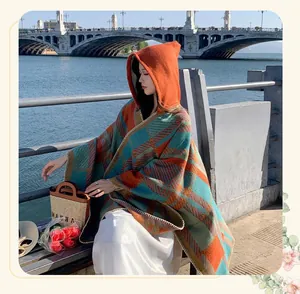Detailed view of women's vintage plaid hooded poncho cape in outdoor autumn setting