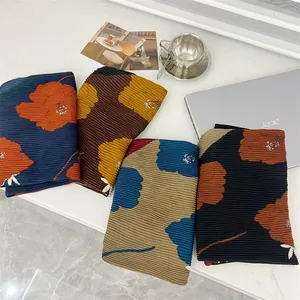 Detailed macro view of pleated floral cotton linen square scarves in four colors.