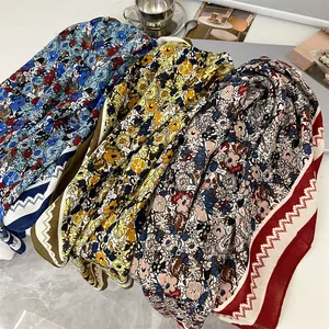 Detailed view of multiple 90cm cotton-linen square scarves with vintage floral patterns.