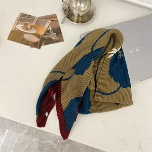 Detailed view of blue floral pleated cotton-linen square scarf on white desk