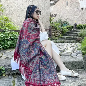 Detailed view of ethnic paisley shawl with tassels on an Asian model outdoors