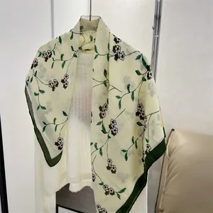 Detail of a floral print cotton linen square scarf featuring a dark green border