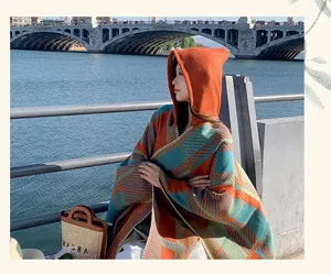 Retro plaid hooded poncho shawl for women in orange and teal colors shown outdoors