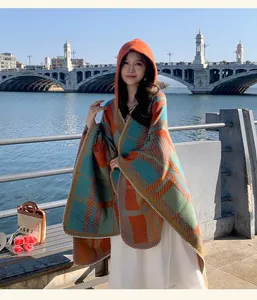 Elegant hooded plaid shawl poncho for women shown in a scenic outdoor lifestyle shot