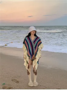 Böhmisches Strick-Poncho mit Ethno-Zickzack-Muster und Quasten am Strand präsentiert