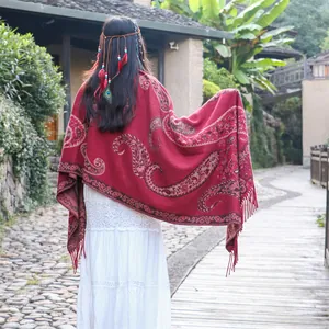 Detailed back view of a red ethnic style shawl with paisley patterns and tassels