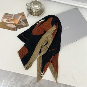 Detailed shot of a pleated floral square scarf on a modern desktop setting