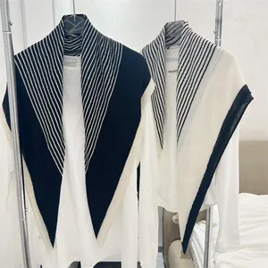 Detailed view of the plissé texture on these black and white striped square scarves