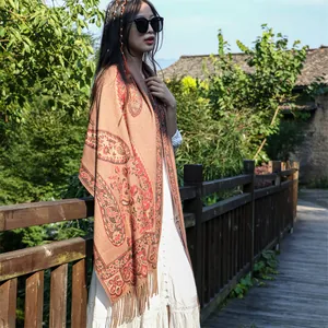 Ethnic paisley patterned shawl with fringe detail worn by model in outdoor setting