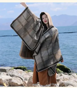 Retro plaid hooded poncho detailed view on a model by the lake, warm autumn outerwear.