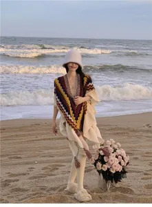 Gestrickter Ethno-Poncho mit bunten Zickzack-Mustern für Reisefotografie am Meeresufer