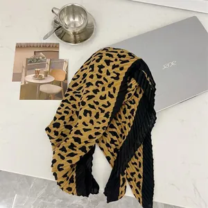 Detailed view of a leopard print pleated square scarf featuring an elegant crinkled texture
