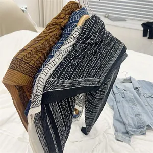 Close-up detail of three pleated 90cm cotton linen square scarves with geometric patterns