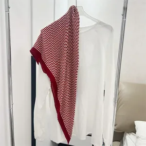 Detailed view of a red and white striped pleated cotton linen square scarf on a white shirt