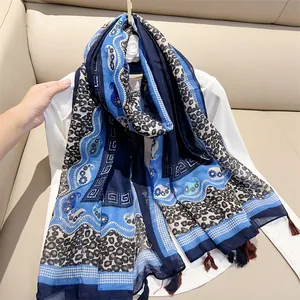 Close-up detail of blue ethnic style shawl featuring leopard print and paisley patterns