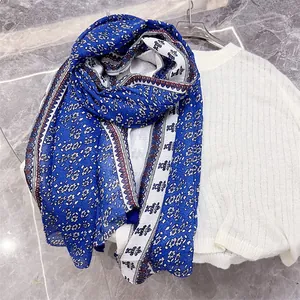 Detailed view of blue and white bohemian cotton linen scarf with elegant floral patterns