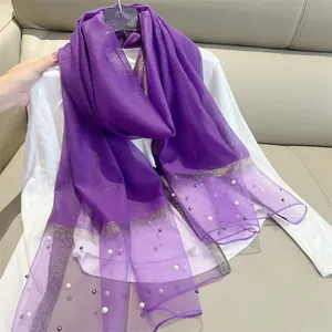 Detail shot of purple imitation silk scarf with pearl accents and gold glitter border