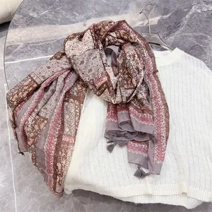 Close-up detail of vintage ethnic paisley print and grey tassels on a cotton-linen feel scarf