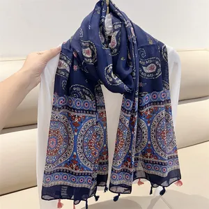 Detailed view of the vintage paisley floral print and tassel edges on the scarf