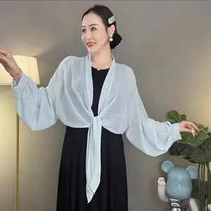 Detailaufnahme eines hellblauen Pailletten-Chiffon-Schals mit eleganten Laternenärmeln.