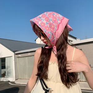 Detailansicht eines rosa geblümten Baumwoll-Bandanas als modisches Sommerkopftuch.