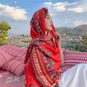 Vibrant red ethnic patterned scarf shawl worn by woman in scenic outdoor setting