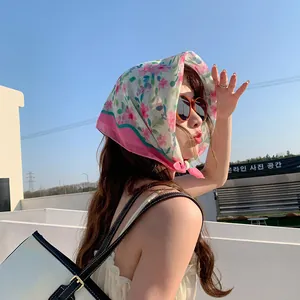 Mujer joven con un pañuelo de algodón y lino de flores como pañoleta al aire libre.