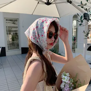 Asiatisches Model trägt ein florales Baumwollkopftuch zum Sonnenschutz im Freien