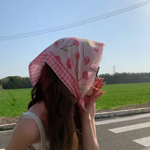 Vista detallada de pañuelo de algodón y lino rosa con estampado de cerezas y cuadros