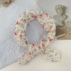 Vista detallada de bufanda cuadrada crema con estampado floral rosa y morado artístico