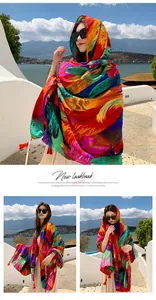 Multi-colored ethnic style scarf with feather patterns and tassels worn by a model