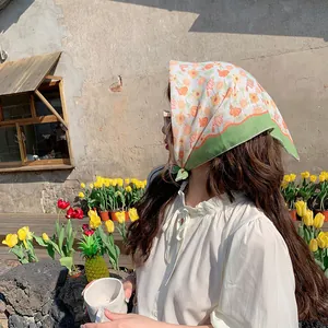 Geblümtes Baumwolltuch für Damen, getragen in einem sonnigen Garten im Freien.