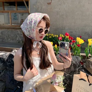 Hermosa mujer asiática con un pañuelo vintage de algodón y lino floral en un jardín