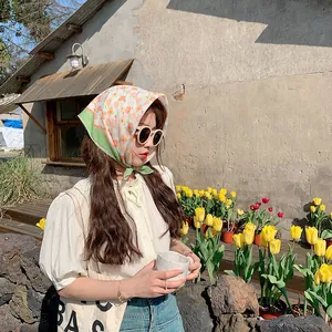 Elegantes Modell trägt ein Vintage-Baumwollkopftuch mit Blumenmuster in einem Garten
