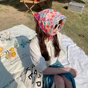 Pañuelo de algodón y lino con flores usado por una modelo en un entorno de picnic