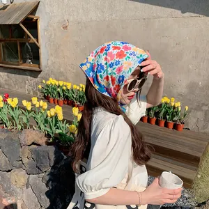 Modelo asiática con un pañuelo de algodón y lino con estampado de flores al aire libre