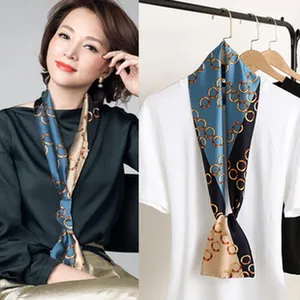Close-up of elegant satin scarf with golden chain print on model and hanger