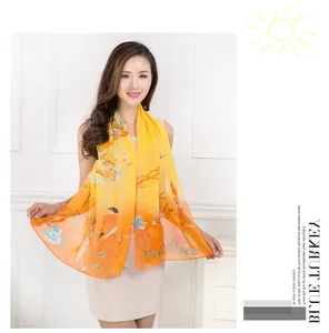 Detail of lightweight chiffon scarf with magpie and floral print in orange gradient