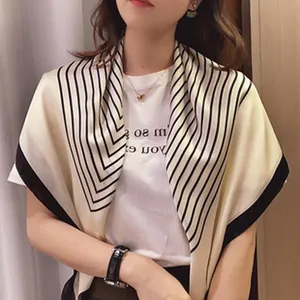 Detail of elegant satin silk scarf with black striped borders worn by a woman