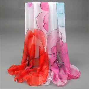 Close-up detail of lightweight chiffon scarf with elegant red and pink floral prints