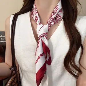 Close-up of a red and white paisley print silk scarf tied as a stylish necktie accessory