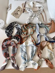 Variety of vintage paisley pattern silk square scarves tied in knots for fashion accessory.