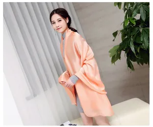 Elegant peach satin imitation silk long shawl worn by a model for sun protection