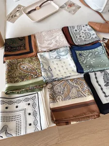Close-up of assorted vintage paisley silk square scarves in various elegant colors and patterns.