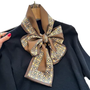 Foulard en soie marron élégant avec motifs vintage noué en ruban sur un pull noir
