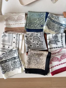Top view of assorted vintage paisley pattern silk square scarves in various colors and styles