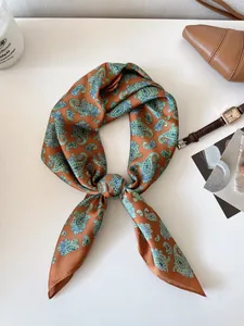 Detailed view of vintage paisley pattern silk scarf for women in brown and green tones