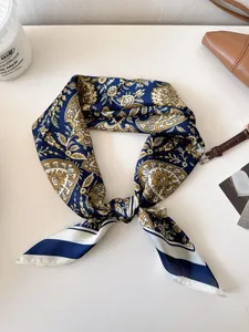Close-up detail of high-quality vintage paisley pattern on a navy blue and gold silk scarf